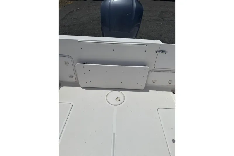 Slide: The Image of 2006 Pro-Line 24 Walkaround boat deck with storage compartments and outboard motor. - 13