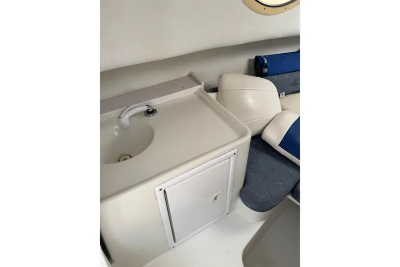 Slide: The Image of 2006 Pro-Line 24 Walkaround boat interior with sink and seating area. - 21