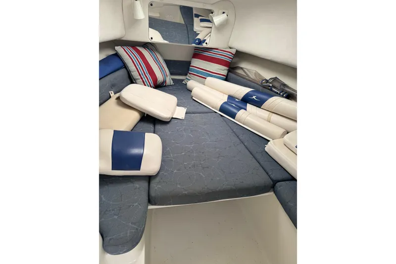 Slide: The Image of 2006 Pro-Line 24 Walkaround cabin interior with cushions and striped pillows. - 22