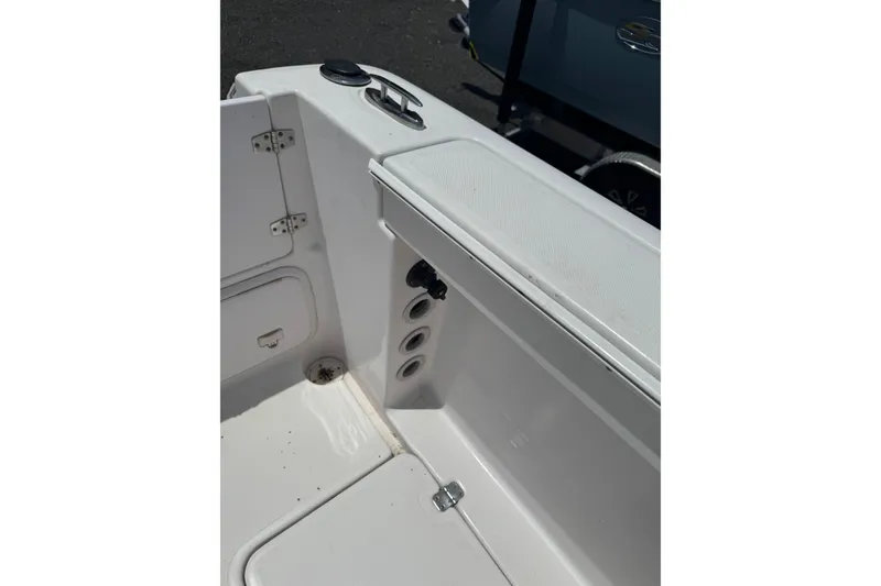 Slide: The Image of 2006 Pro-Line 24 Walkaround boat interior, featuring storage compartments and clean white surfaces. - 12