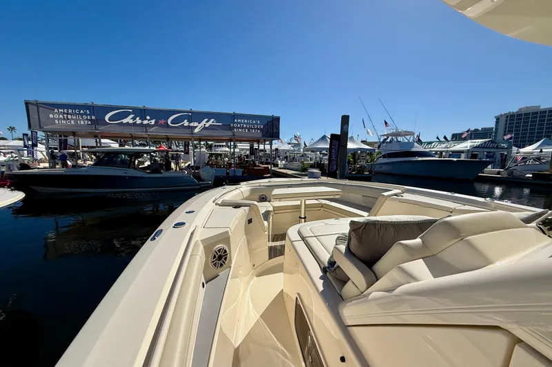 Slide: The Image of Luxury 2026 Scout 400 LXF boat at a marina, showcasing elegant seating and nearby Chris-Craft display. - 12