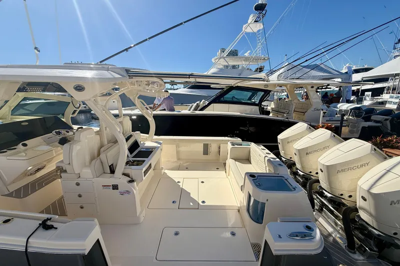 Slide: The Image of 2026 Scout 400 LXF boat with Mercury engines, docked under clear blue sky. - 19