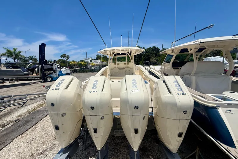 Slide: The Image of 2026 Scout 400 LXF boat with four powerful V10 engines docked under a clear blue sky. - 2