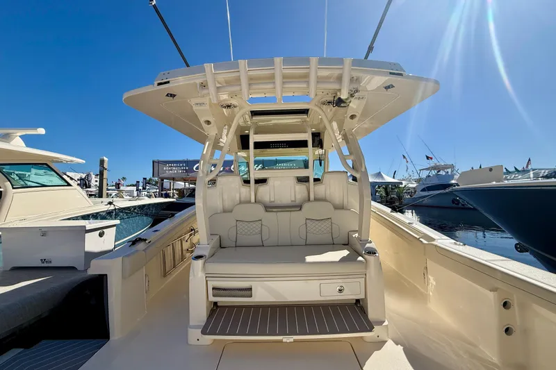 Slide: The Image of 2026 Scout 400 LXF luxury boat interior with seating and helm, docked under clear blue sky. - 6