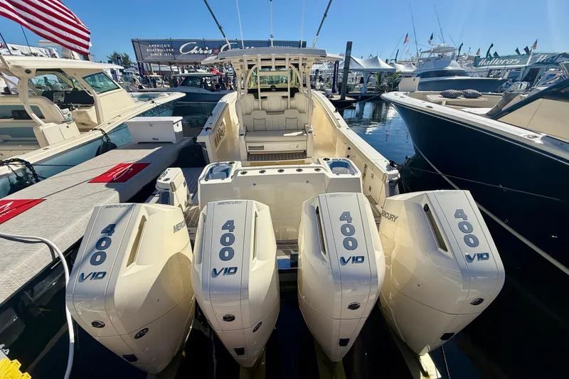 Slide: The Image of 2026 Scout 400 LXF boat with four Mercury 400 V10 engines at a marina display. - 3