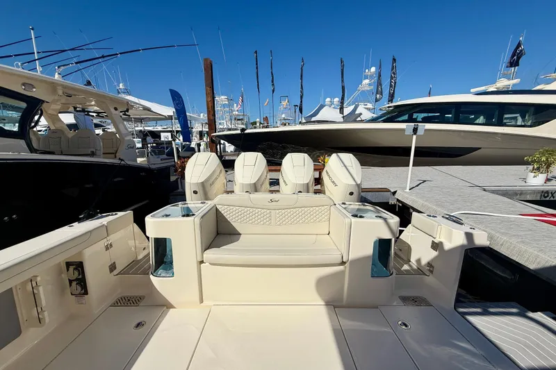 Slide: The Image of 2026 Scout 400 LXF luxury boat interior with seating and outboard motors at a marina. - 5