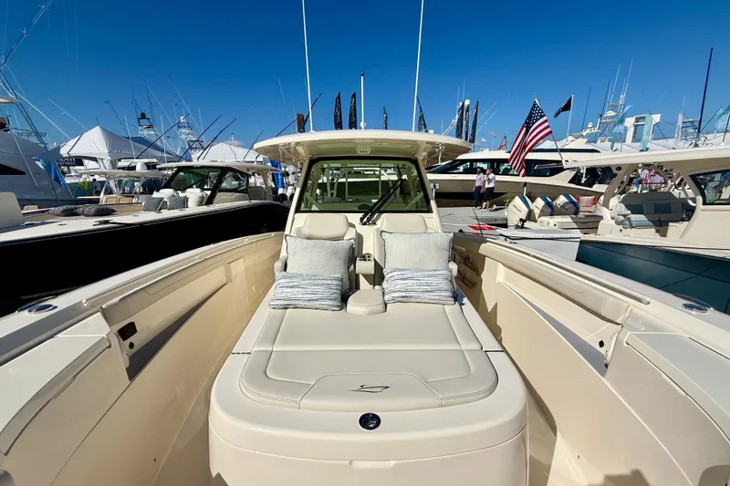 Slide: The Image of 2026 Scout 400 LXF luxury boat with plush seating at a marina under clear blue skies. - 13