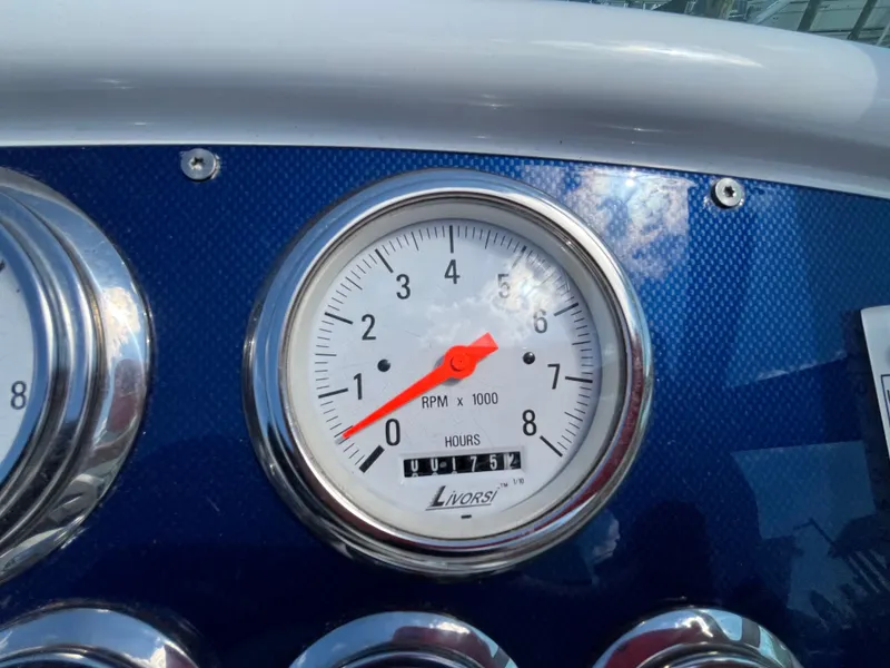 Slide: The Image of Close-up of a tachometer with a red needle on a blue background. - 8