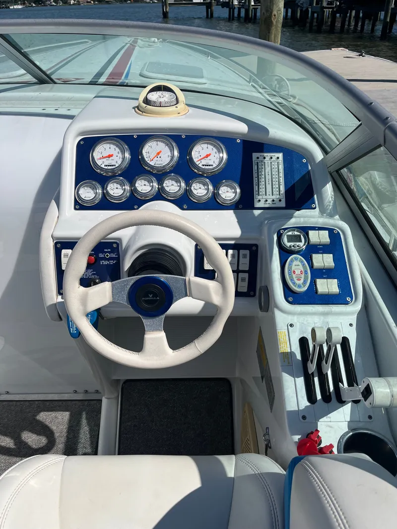 Slide: The Image of The cockpit of a 2004 Formula 292 FASTech with a white steering wheel and blue instruments. - 4