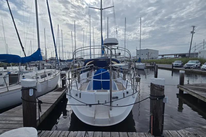 Slide: The Image of 1993 Beneteau Oceanis 370 sailboat docked at a marina under cloudy skies. - 4