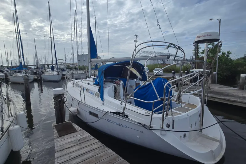 Slide: The Image of Sailboat Beneteau Oceanis 370, 1993 model, docked at marina with overcast sky. - 3
