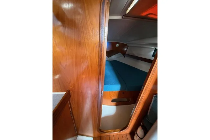 Slide: The Image of Interior cabin of 1993 Beneteau Oceanis 370 sailboat with wooden finish and blue bedding. - 13