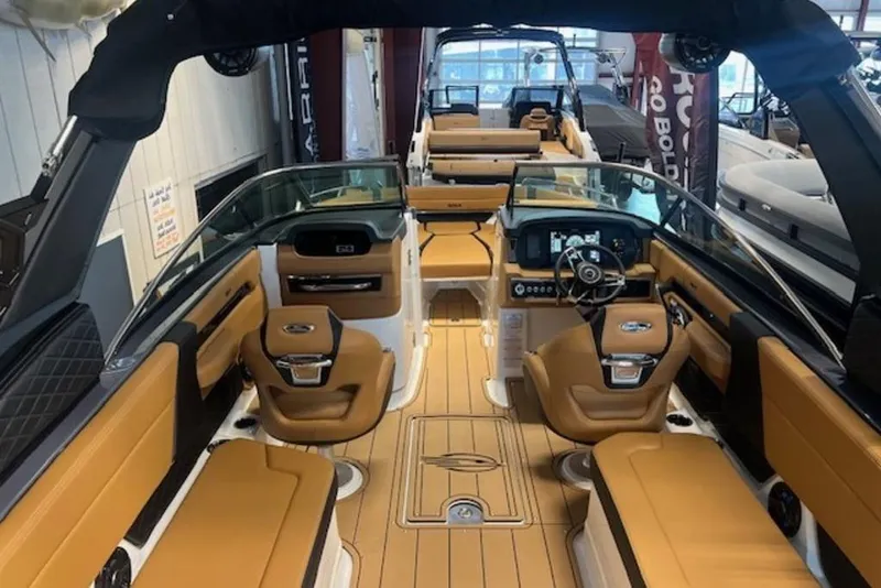 Slide: The Image of 2025 Chaparral 2870 SSX boat interior with luxurious tan seating and modern dashboard. - 12