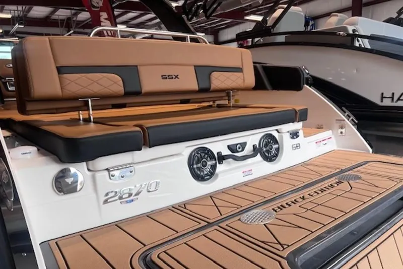 Slide: The Image of 2025 Chaparral 2870 SSX boat with luxurious seating and sleek design in showroom. - 8
