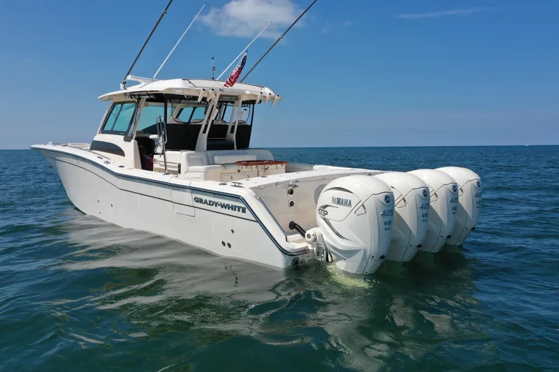 Slide: The Image of 2019 Grady-White Canyon 456 boat with four Yamaha engines on open water. - 8
