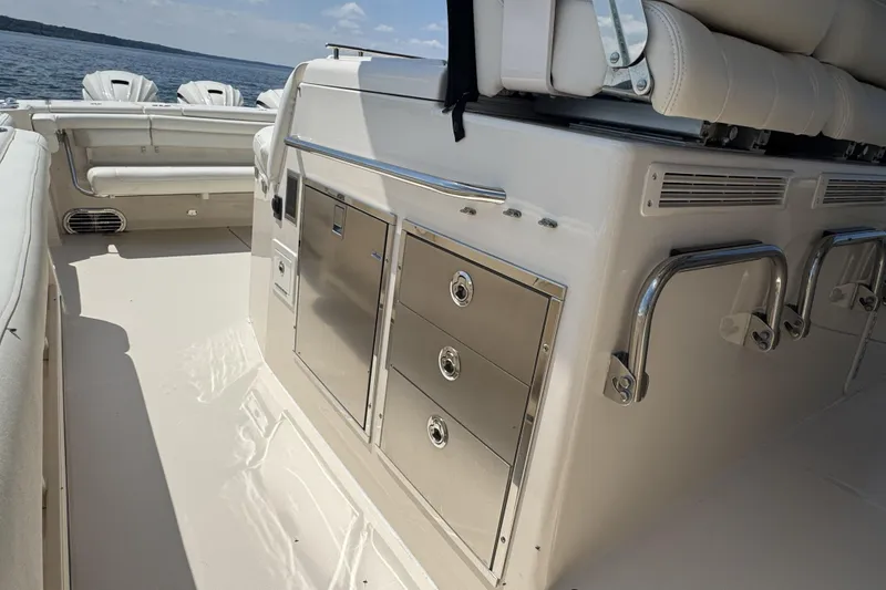 Slide: The Image of 2019 Grady-White Canyon 456 boat interior with seating and storage, on a sunny day. - 18