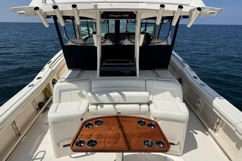 Slide: The Image of 2019 Grady-White Canyon 456 boat interior with seating and table on open water. - 15