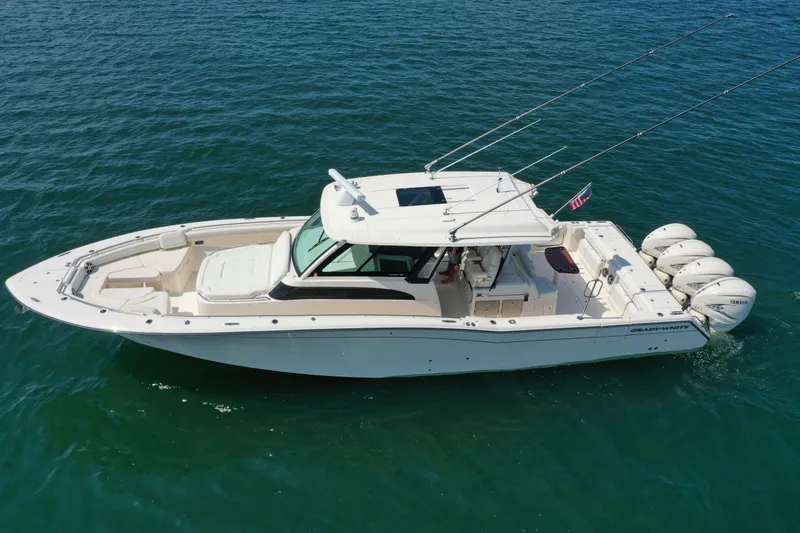 Slide: The Image of 2019 Grady-White Canyon 456 boat on open water, featuring four outboard engines. - 5