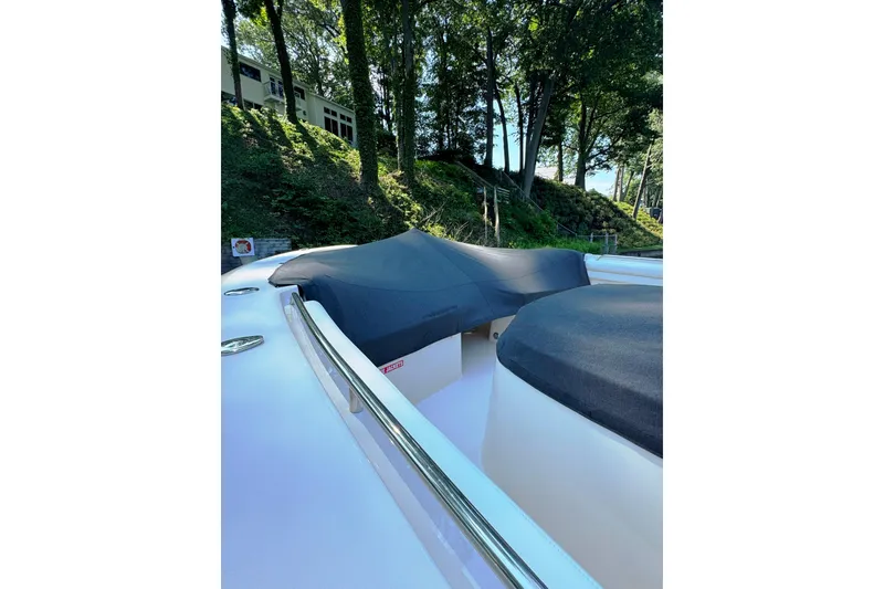 Slide: The Image of 2019 Grady-White Canyon 456 boat with covered seating, surrounded by lush greenery. - 56