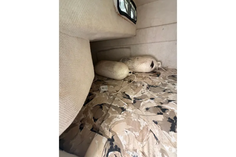 Slide: The Image of Interior cabin of 1999 Sea Ray 240 Sundancer with patterned upholstery and boat fenders. - 14