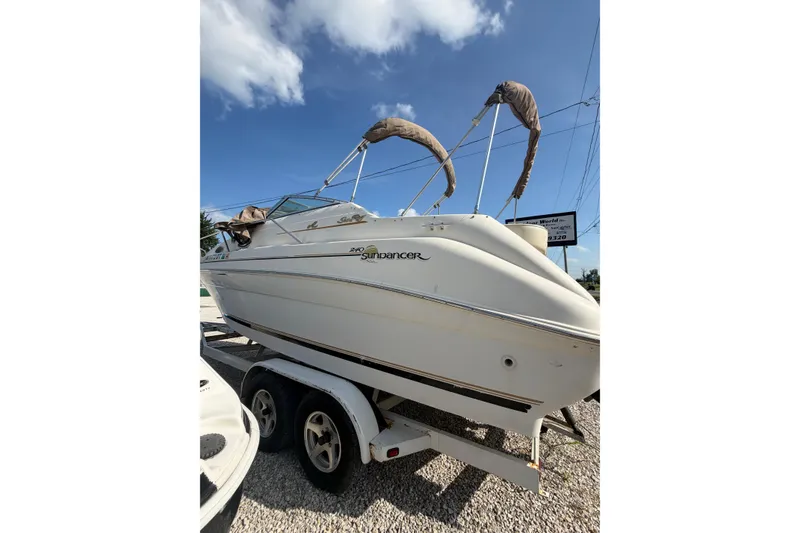 The Image of 1999 Sea Ray 240 Sundancer boat on trailer under blue sky. - 0