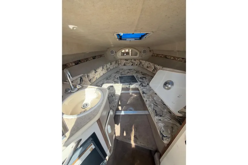 Slide: The Image of Interior of 1999 Sea Ray 240 Sundancer boat with sink and seating area. - 12