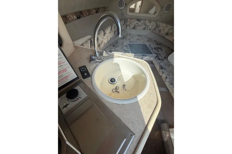 Slide: The Image of 1999 Sea Ray 240 Sundancer interior with sink and seating area. - 13