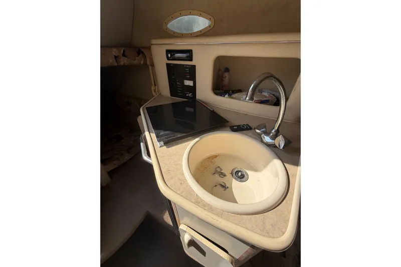 Slide: The Image of 1999 Sea Ray 240 Sundancer cabin interior with sink and control panel. - 17