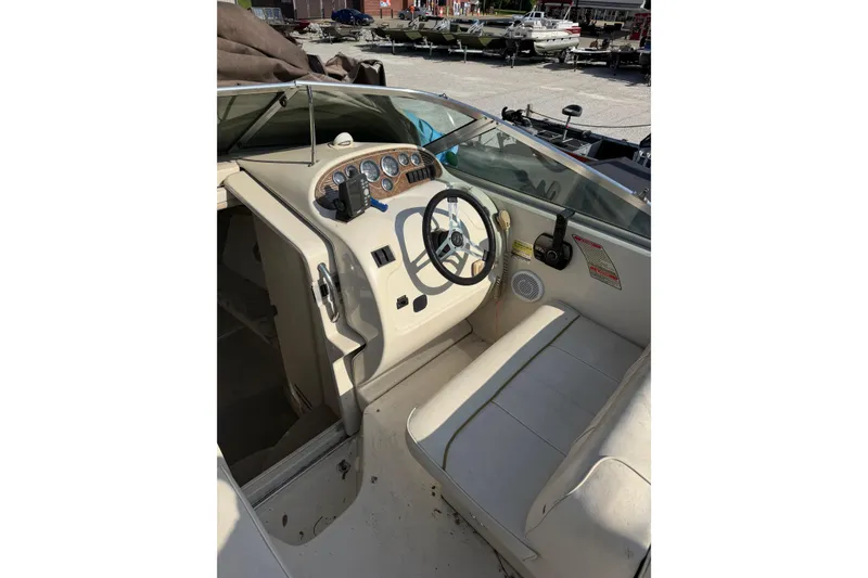 Slide: The Image of 1999 Sea Ray 240 Sundancer boat cockpit with steering wheel and control panel. - 5