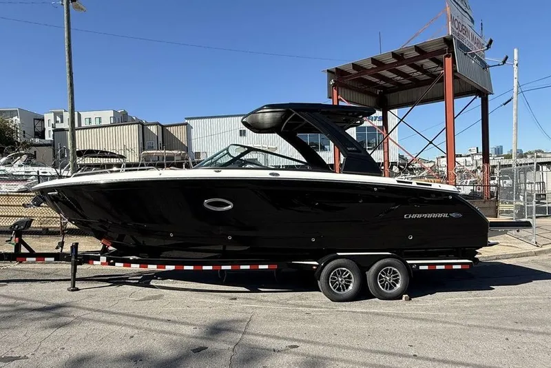 The Image of 2026 Chaparral SSX 30 boat on trailer, sleek black design, outdoor setting. - 1