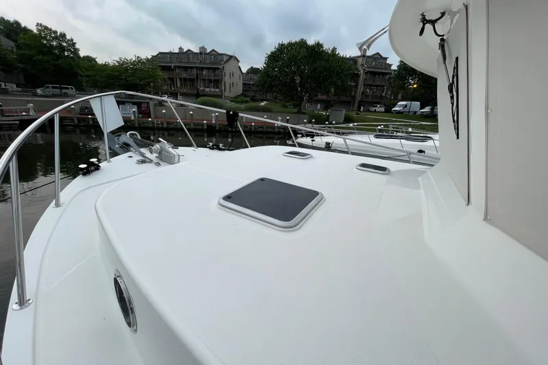 Slide: The Image of 2006 American Tug 41 docked, showcasing spacious deck and sleek design. - 24