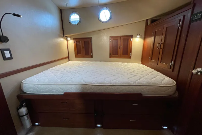 Slide: The Image of Cozy cabin bedroom in 2006 American Tug 41 with wooden storage and porthole windows. - 20