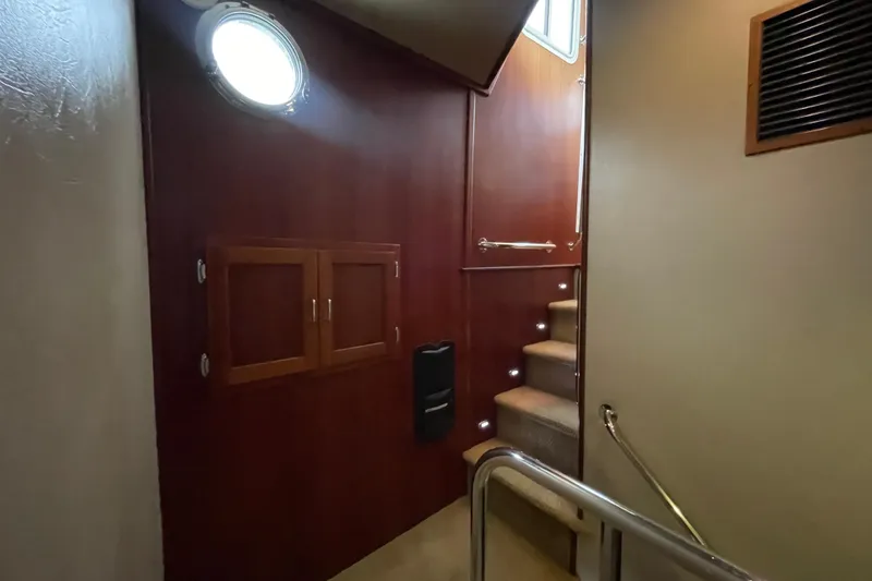 Slide: The Image of Interior stairway of 2006 American Tug 41 with wooden paneling and porthole window. - 14