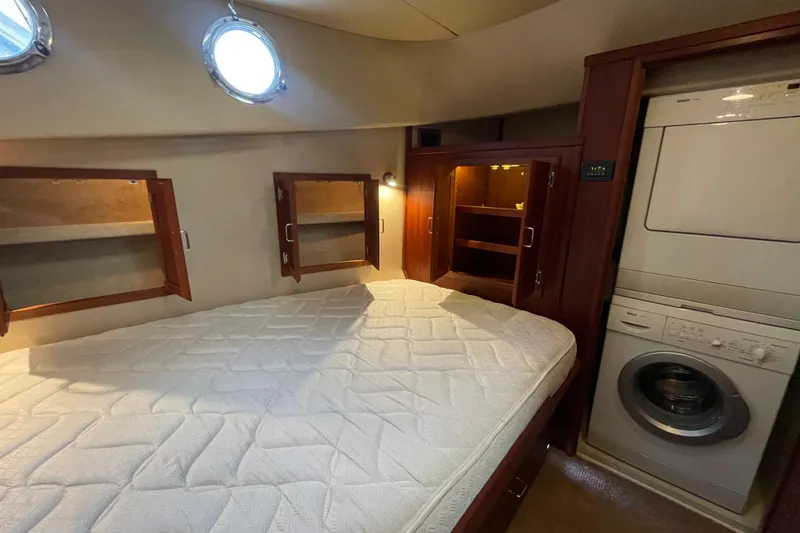 Slide: The Image of Cozy cabin interior of 2006 American Tug 41 with bed, storage, and washer-dryer unit. - 32