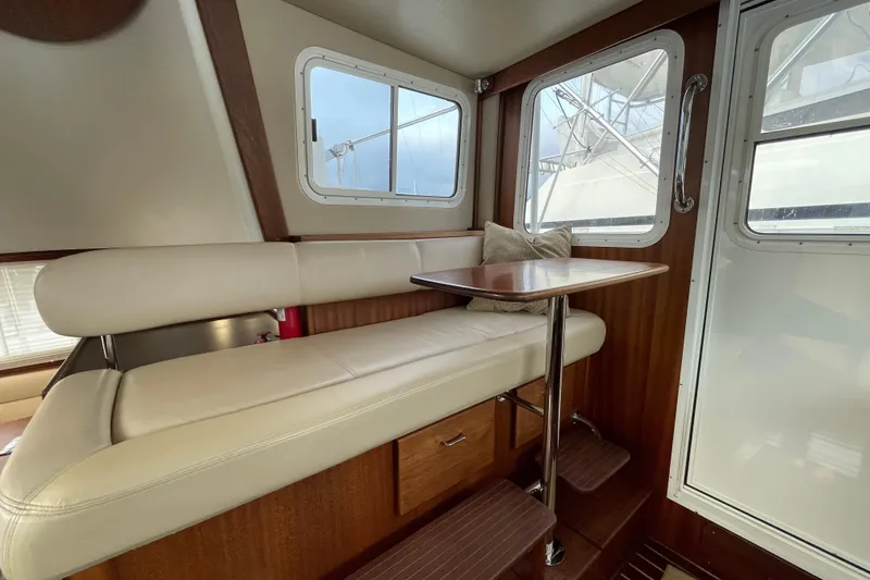 Slide: The Image of Interior of a 2006 American Tug 41, featuring a cozy seating area with a table. - 6