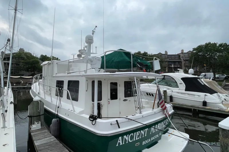 Slide: The Image of American Tug 41, 2006 model, docked at marina with overcast sky. - 10