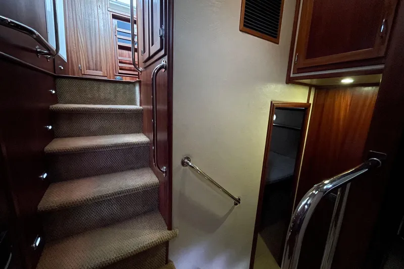 Slide: The Image of Interior staircase of 2006 American Tug 41, featuring carpeted steps and wooden cabinetry. - 19