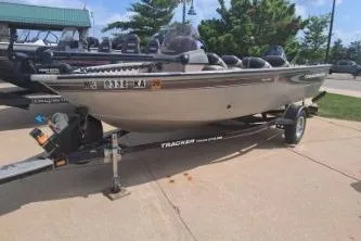 The Image of 2006 Tracker Pro Guide V-16 SC boat on trailer, parked outdoors. - 1