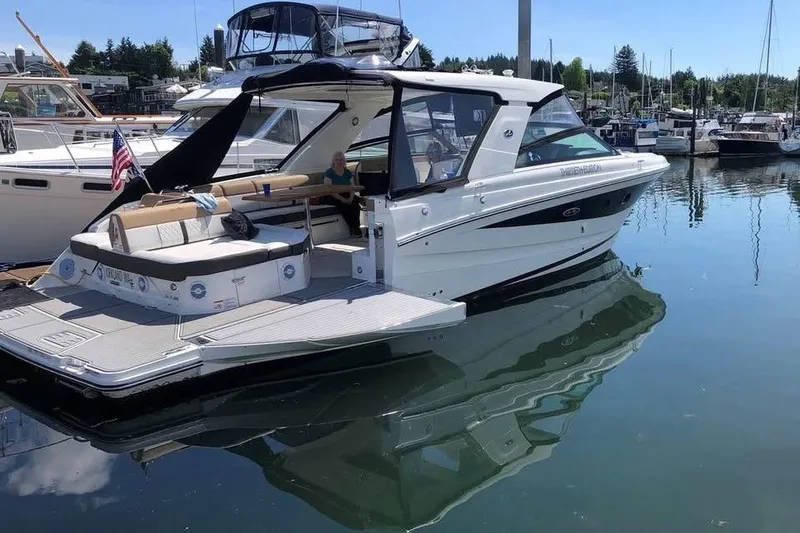 The Image of 2018 Sea Ray SLX 400 boat docked in a marina, reflecting on calm water. - 0