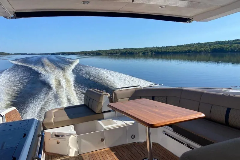 Slide: The Image of 2018 Sea Ray SLX 400 cruising on a serene lake with wake trails. - 1