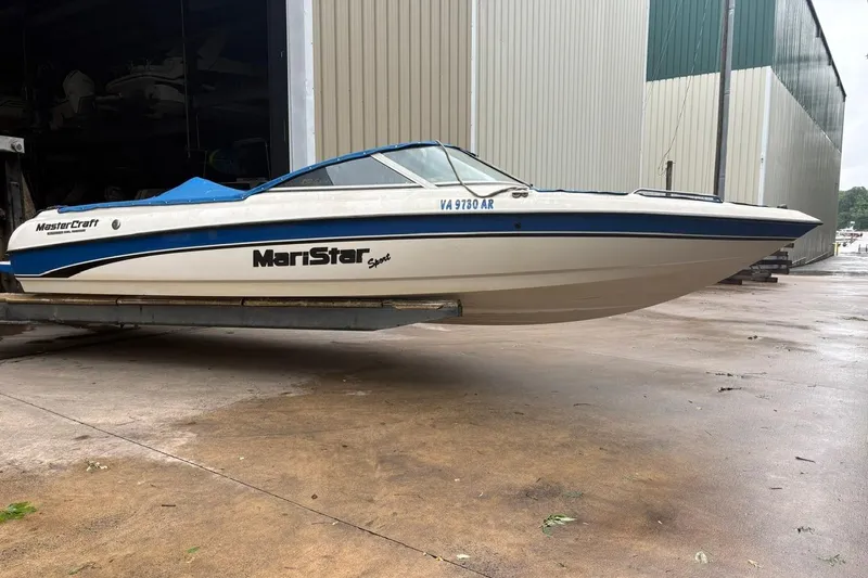 Slide: The Image of 1999 MasterCraft MariStar 230 Sport boat on a trailer outside a storage facility. - 2