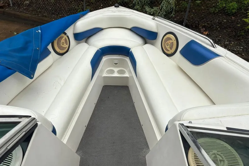 Slide: The Image of 1999 MasterCraft MariStar 230 Sport boat interior with white and blue seating, cup holders, and speakers. - 8