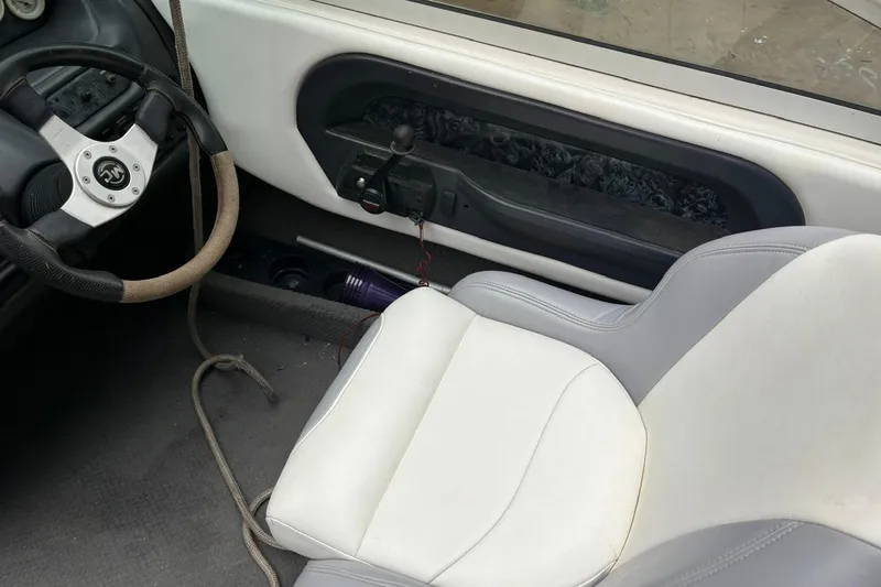 Slide: The Image of Interior of a 1999 MasterCraft MariStar 230 Sport boat, featuring steering wheel and seat. - 6