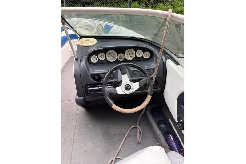 Slide: The Image of 1999 MasterCraft MariStar 230 Sport boat dashboard with steering wheel and gauges. - 9