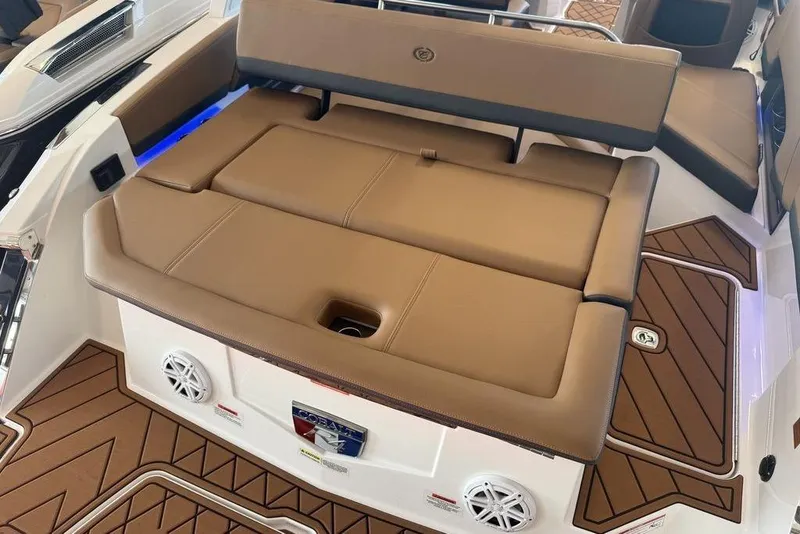 Slide: The Image of 2026 Cobalt R4 boat interior with tan seating and wood-patterned flooring. - 12