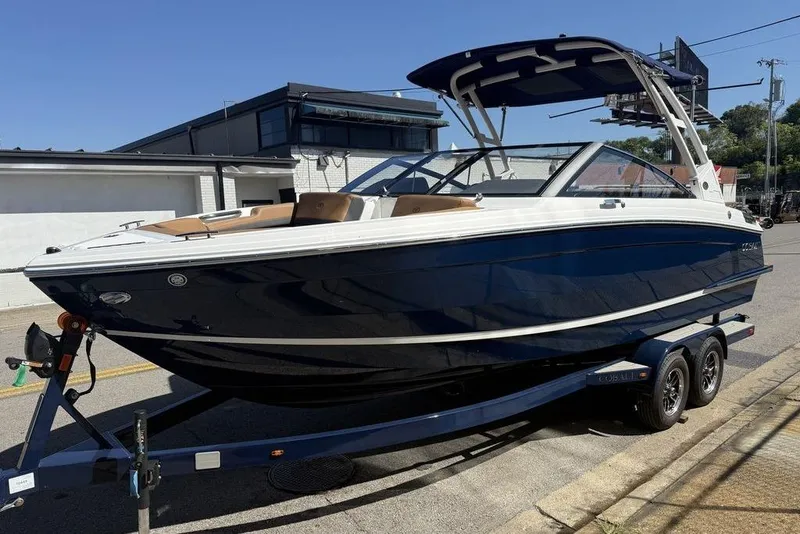 Slide: The Image of 2026 Cobalt R4 boat on trailer, sleek design, navy blue hull, parked outdoors. - 8
