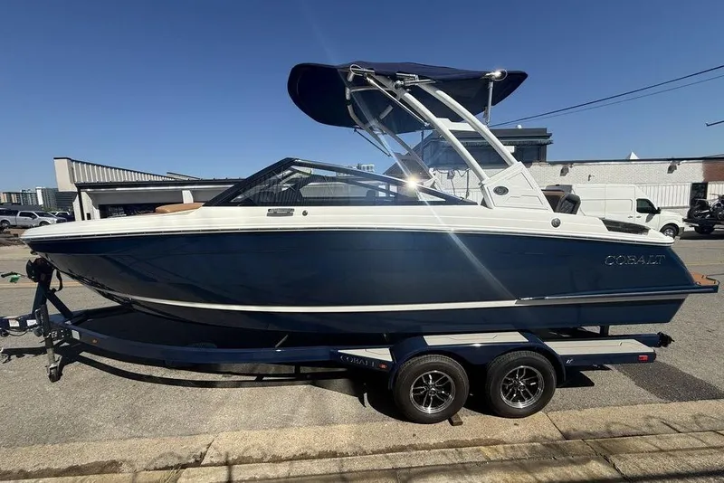 Slide: The Image of 2026 Cobalt R4 boat on trailer, blue and white design, parked outdoors. - 4