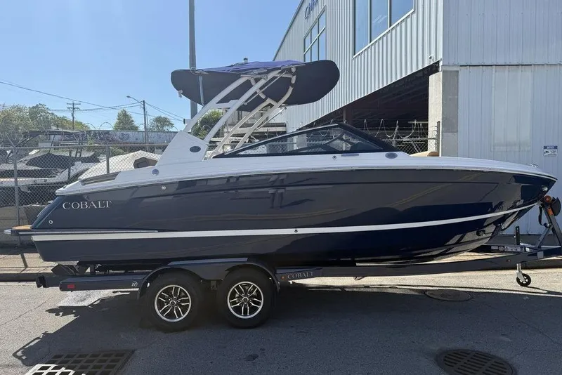 Slide: The Image of 2026 Cobalt R4 boat on trailer, parked outside a building under clear skies. - 9