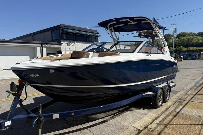 The Image of 2026 Cobalt R4 boat on trailer, parked outdoors under clear blue sky. - 1