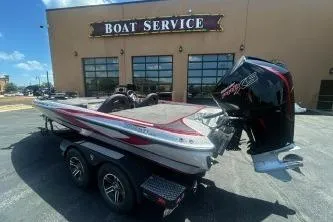 Slide: The Image of 2022 Triton 19 TrX Patriot boat parked outside a boat service center. - 1